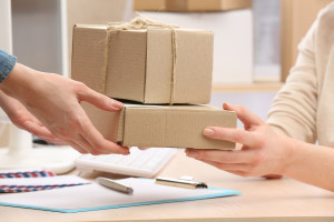 Woman gives parcel in post office