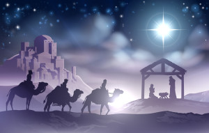 Traditional Christian Christmas Nativity Scene of baby Jesus in the manger with Mary and Joseph in silhouette with wise men