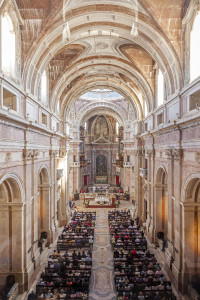 Mafra, Portugal - September 02, 2013: Basilica of the Mafra Palace filled with faithful during the Mass. Baroque architecture. Franciscan religious order.